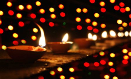 Lit Oil Lamps With Blurred Multicoloured Lights In The Background.