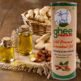 Ghee Store Cold Pressed Groundnut Oil Container With Peanuts, Peanut Oil Bottles, And A Basket Of Peanuts In The Background.