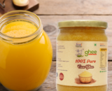 Jar Of 100% Pure A2 Desi Cow Ghee Made In Bilona Method Next To A Glass Container Filled With Ghee On A Wooden Surface.