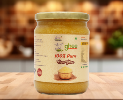 Desi Cow Ghee 1 Kg Price - Pure A2 Bilona Method Ghee. Jar of 100% pure cow ghee on a wooden surface with a blurred background.