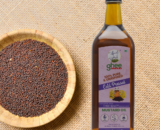 Bottle Of 100% Pure, Unrefined Cold-Pressed Mustard Oil Next To A Bowl Of Mustard Seeds On A Burlap Surface.